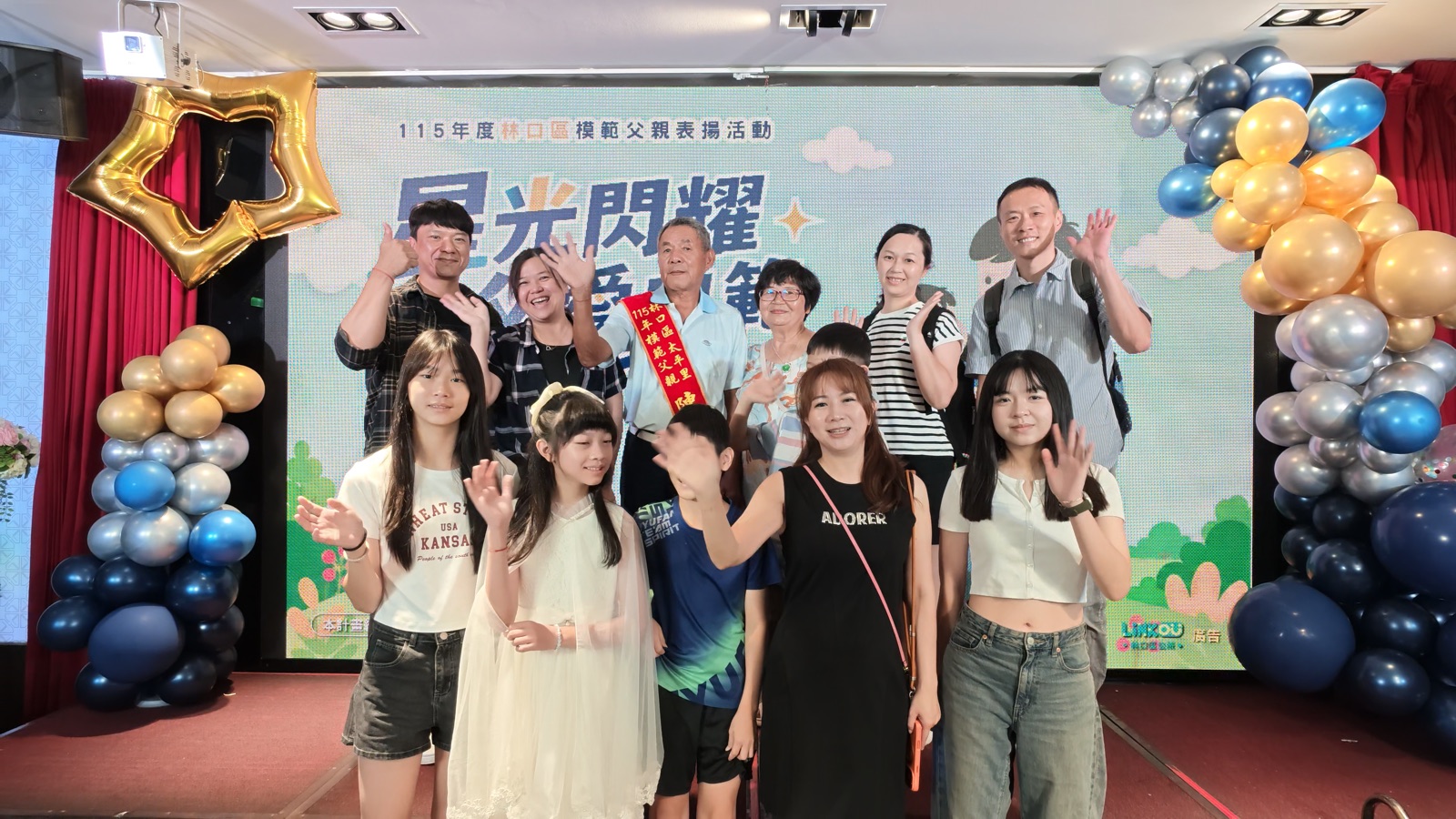 多人在活動背板前比讚合照